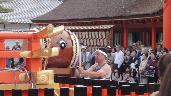 a taiko drummer with a crowd in the background